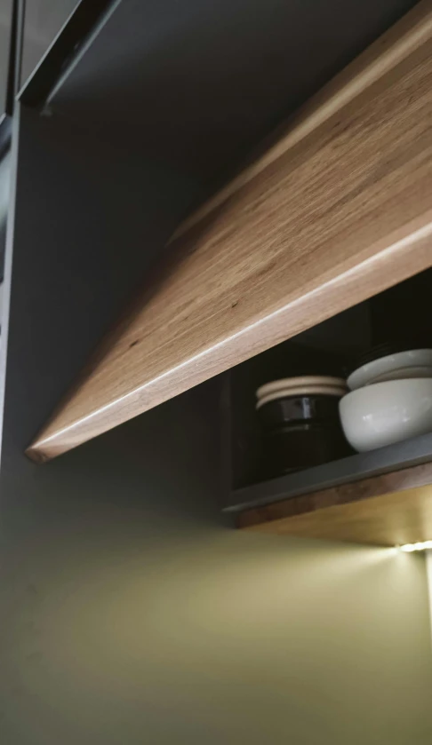 a kitchen cabinet open, showing a bowl and other items on it