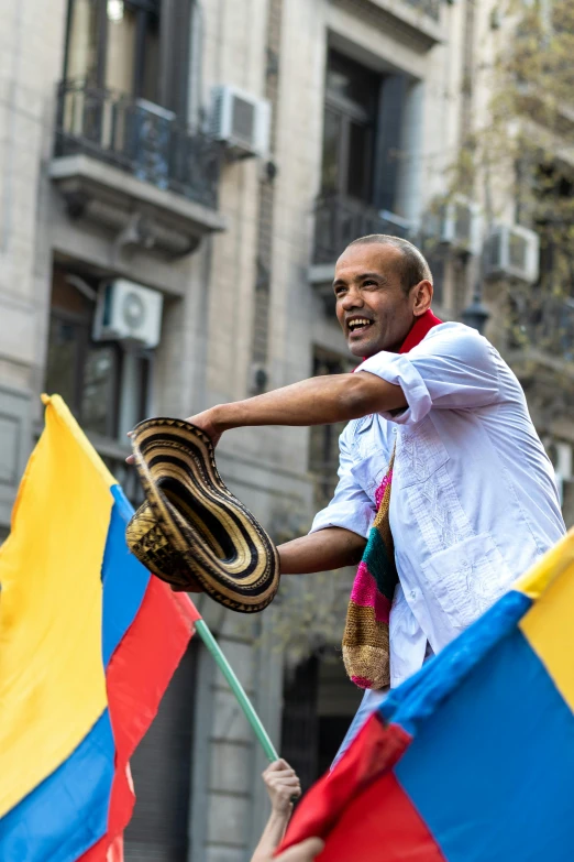 a man in white holds a large snake and some flags