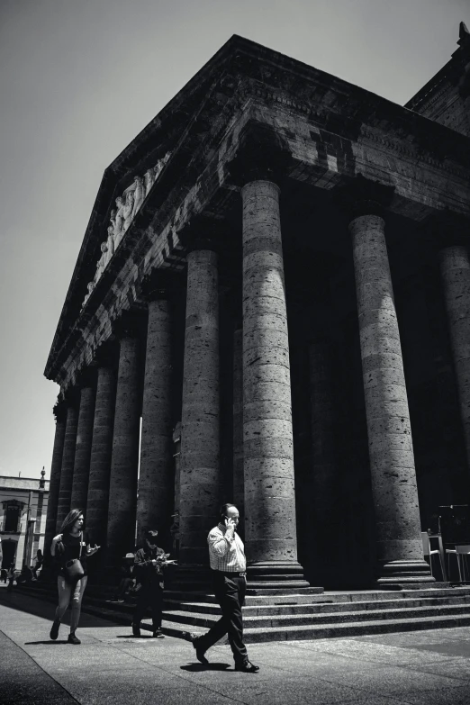 the man is standing outside the big building