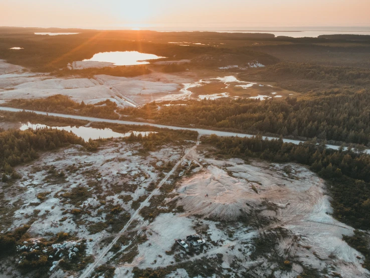 the sun is setting over an area with snowy hills