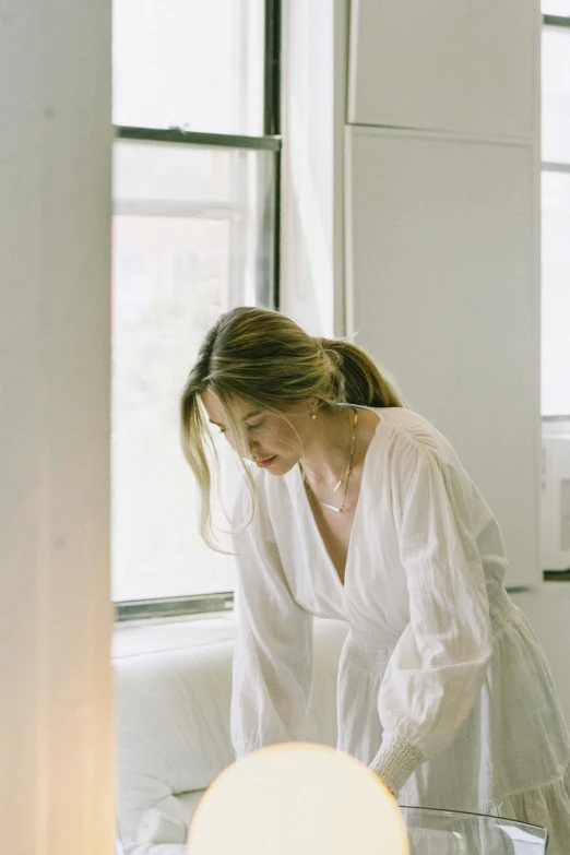 a young woman bending down to look at soing on a table