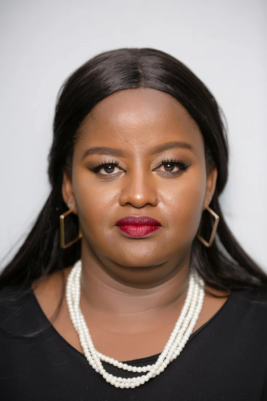 a woman with a necklace and earrings wearing pearls