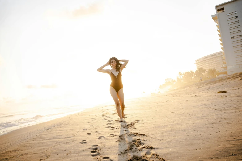 a woman in a bathing suit walking on the beach