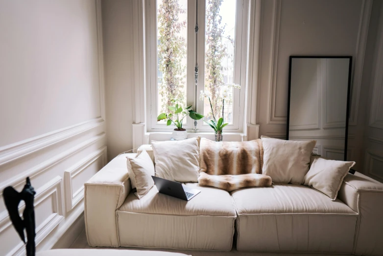 a white couch and mirror in a living room