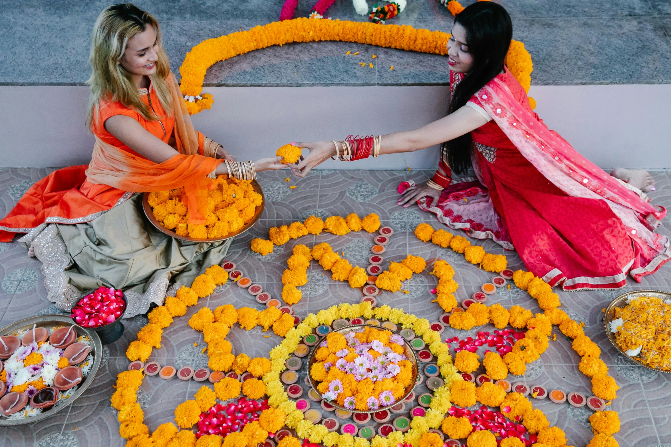 two beautiful young women holding colorful offerings