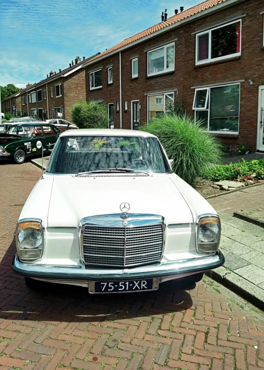 old white car parked in front of apartment building