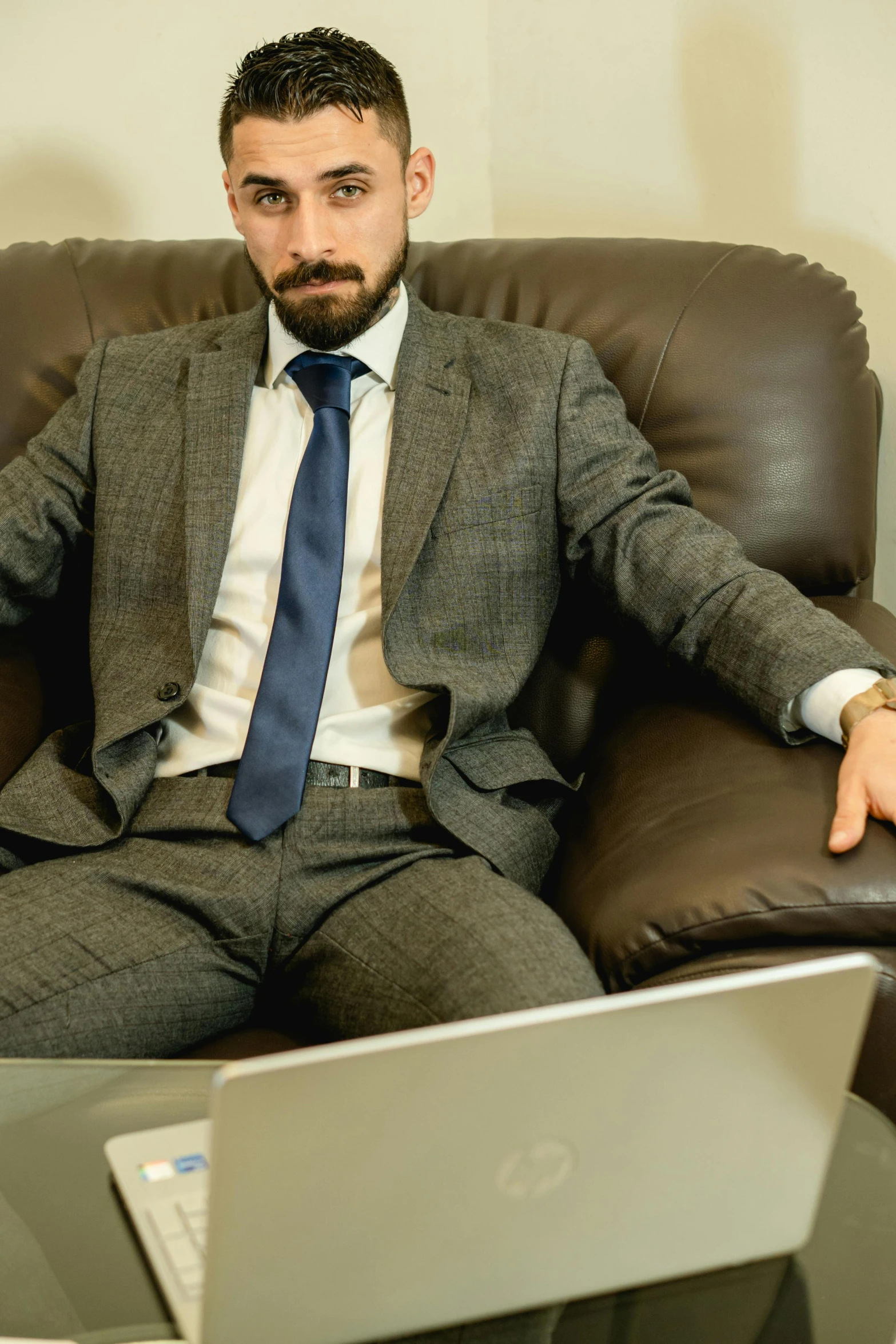 a man in a suite is sitting down with a laptop