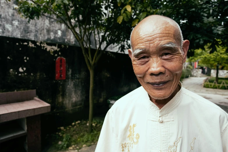 a very old man with an eye patch wearing white clothes