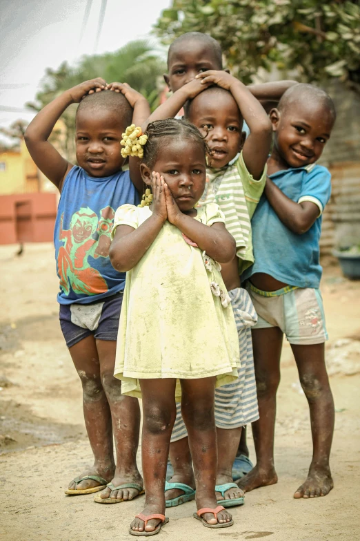 several children pose with their hands together in front of them