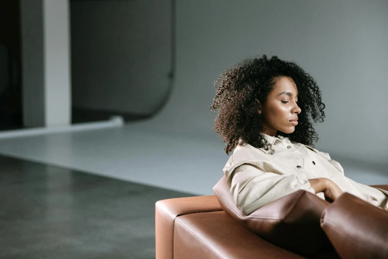 a woman sitting in a chair looking at her cell phone