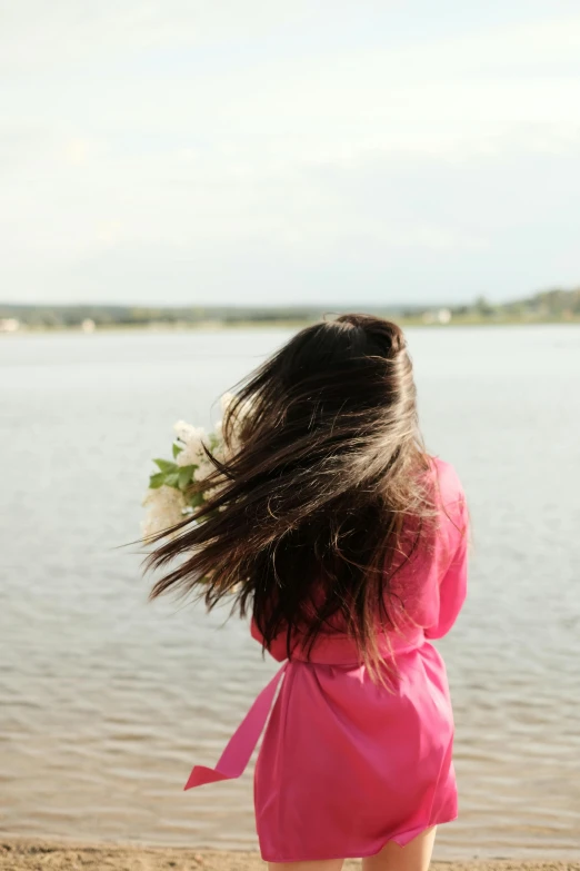 a girl in pink dress and white flower in her hair