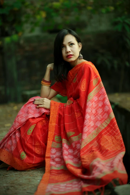 a woman in a red sari poses for a po