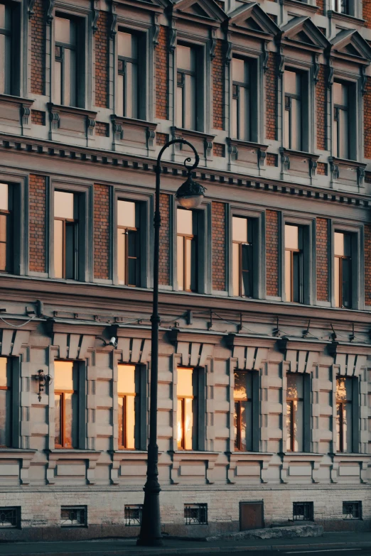 an elegant building in the early evening, lit by a street light