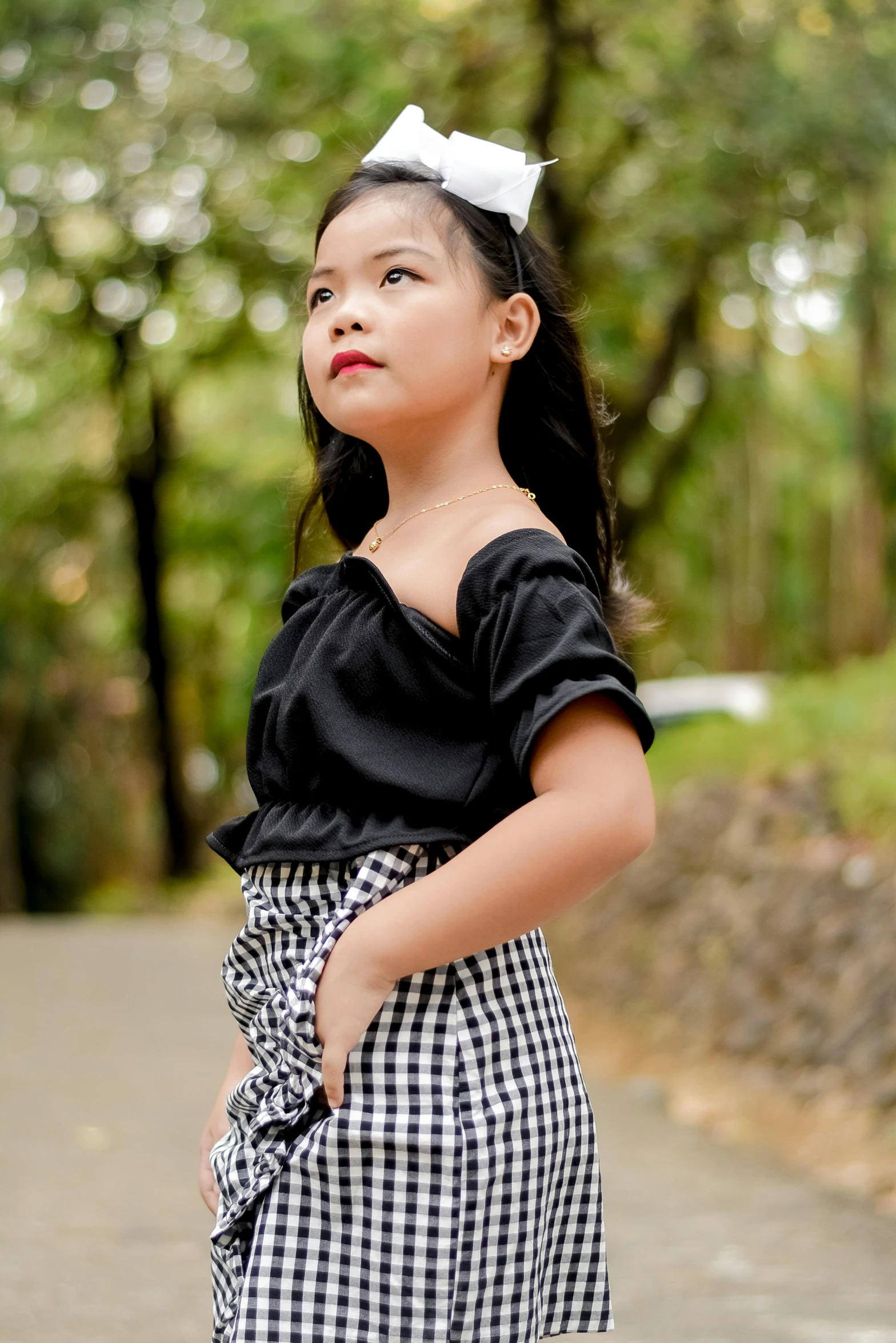 a little girl in a skirt and top posing for the camera