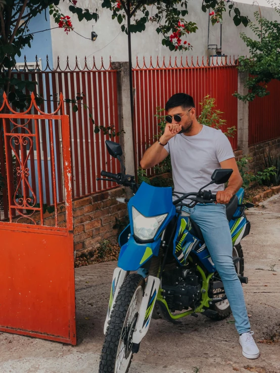 a man sitting on a motorcycle wearing sunglasses