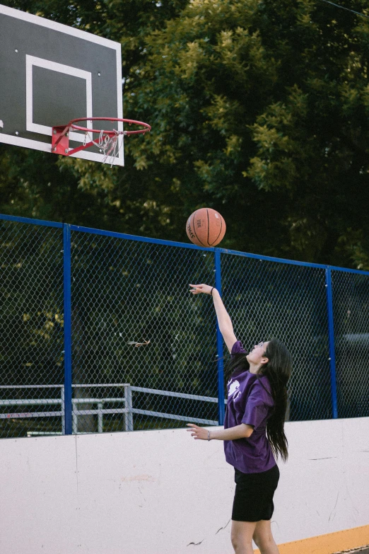 a woman throwing a basketball up into the air