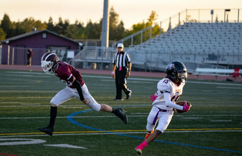 two teams of football players and one is running the ball