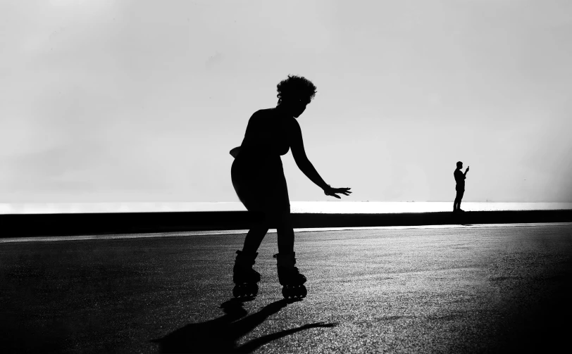 a silhouette of a person skateboarding on the street