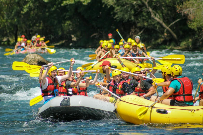 a group of people riding rafts on top of a river