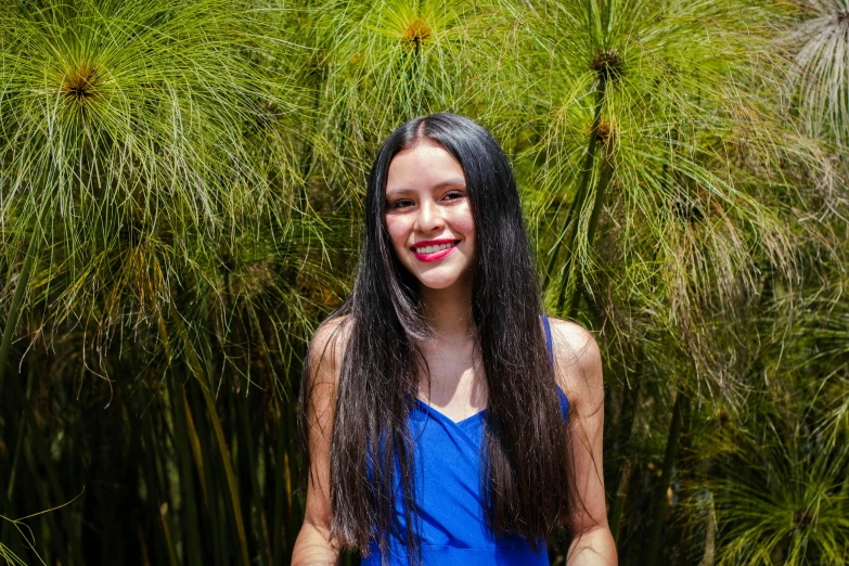 a girl with long dark hair wearing a blue dress