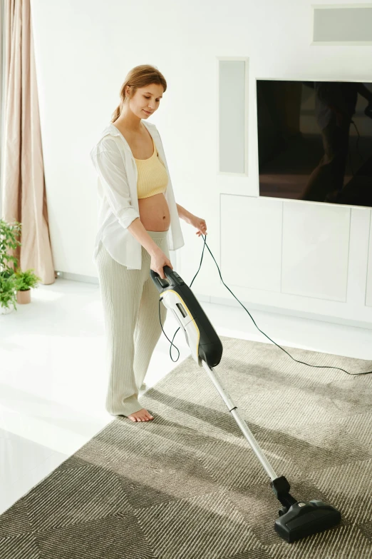 a woman is using the h on on her vacuum