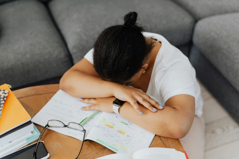 a girl sleeping on a couch with a book, glasses and books