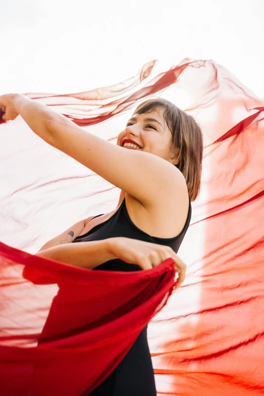 a woman is standing and smiling with her arms extended