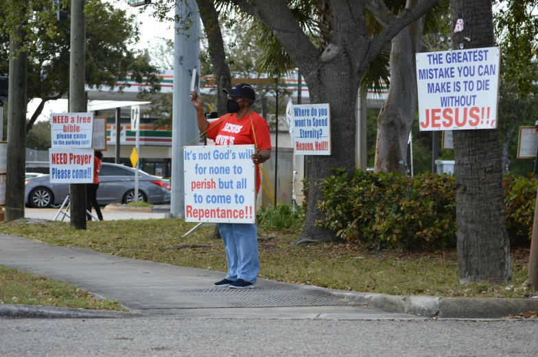 a man is holding a sign and standing outside