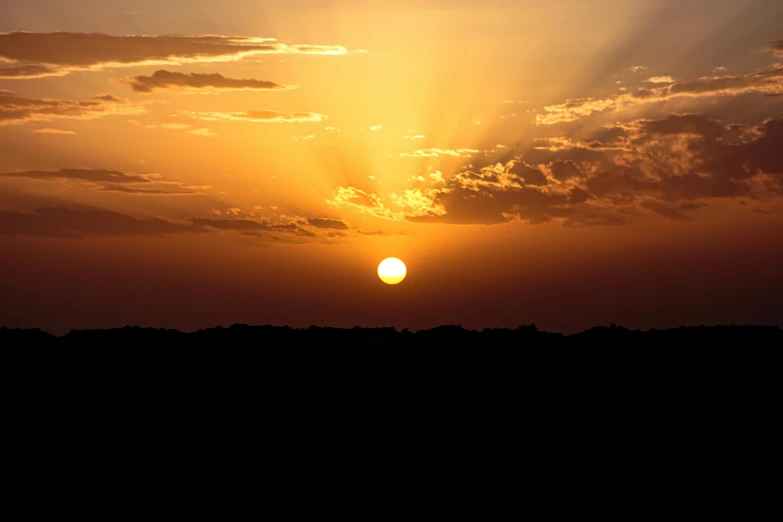 a beautiful sunset is seen from the side of a hill