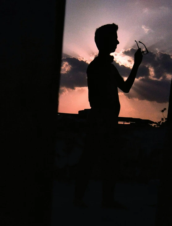 a man looks at his cell phone while standing near the city skyline