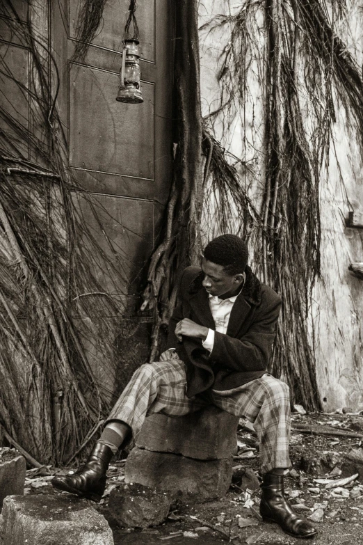 a man sitting on a tree trunk in front of some plants