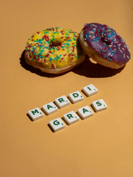 two donuts in the shape of the word march, a crossword made with letters next to them