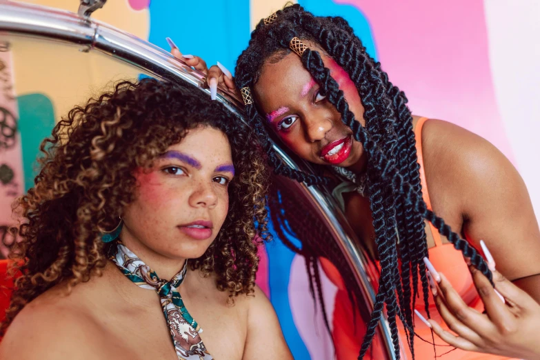 a couple of girls standing together while combing their hair