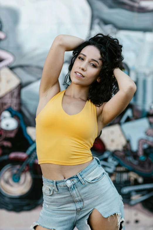 a woman posing for a picture with her hands on her head