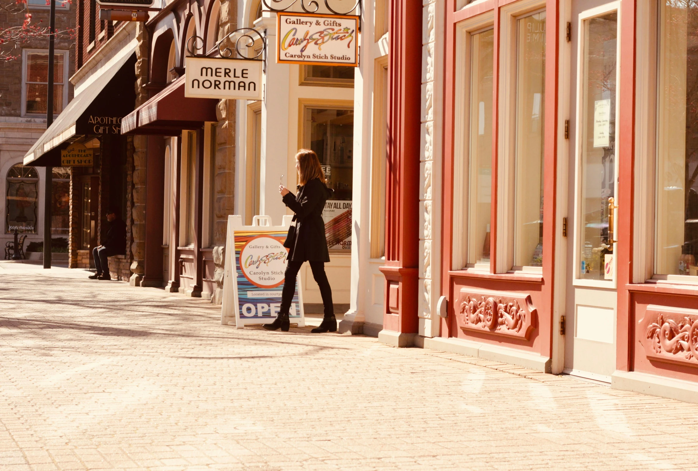 woman in black dress standing on a sidewalk