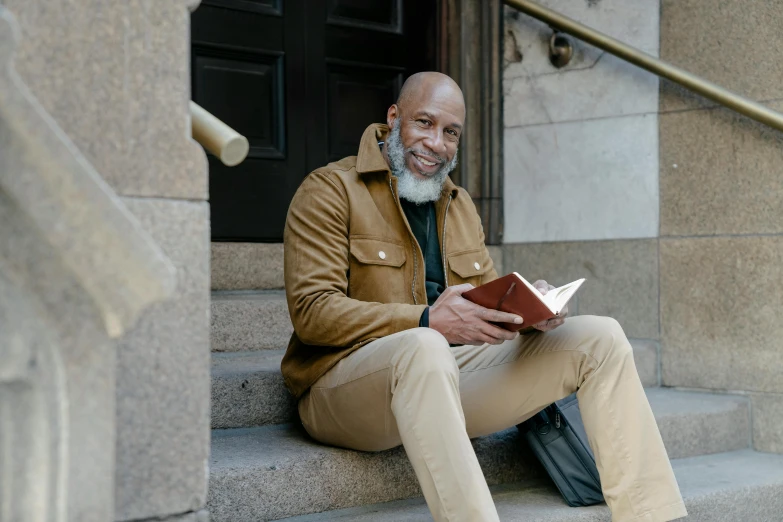 the man is reading a book on the step of some steps