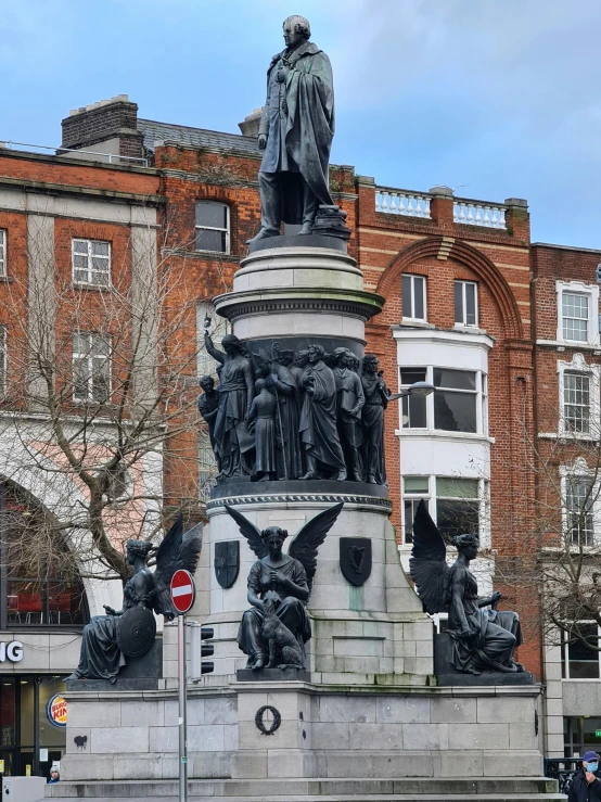 statue with many sculptures around it in front of a building