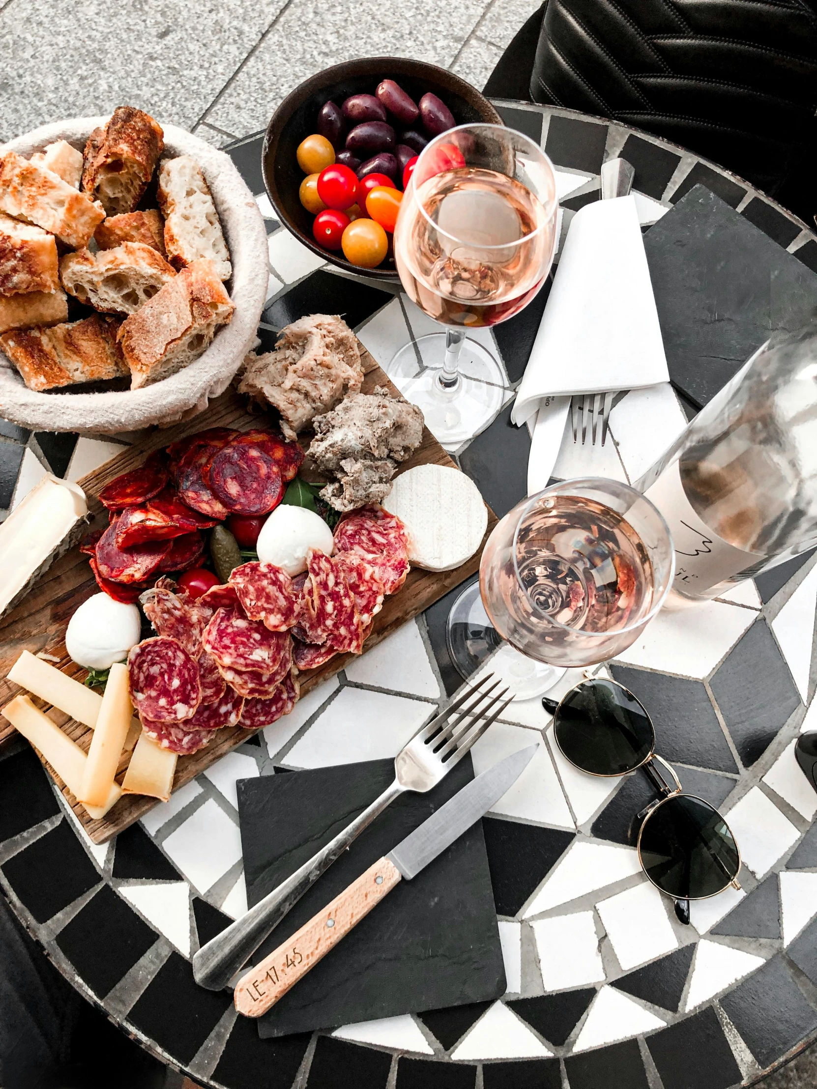 there is a table that has some wine, bread and food on it