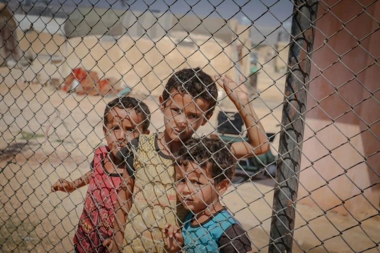 a group of s standing behind a metal fence