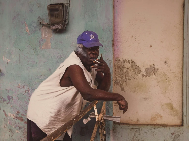 a person standing leaning on a rope and smoking a cigarette