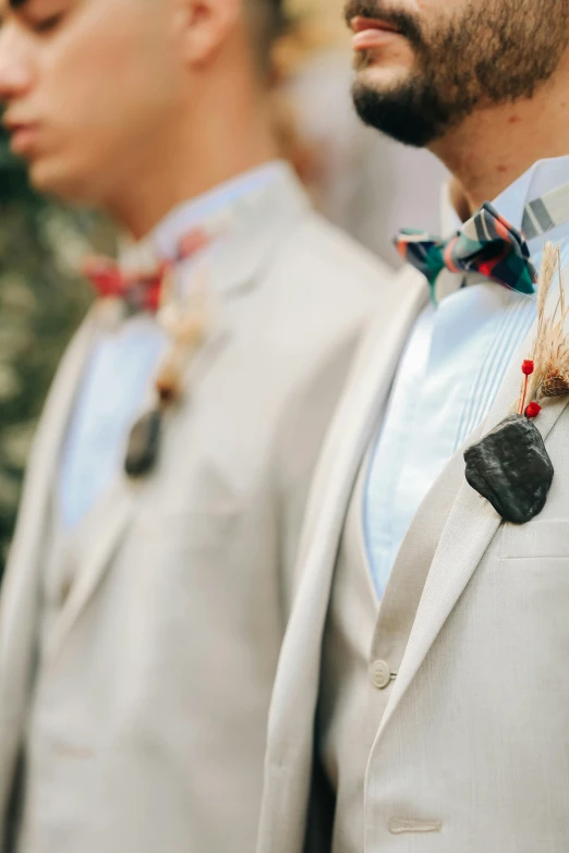 men are wearing bow ties and suits and have medals on their necks