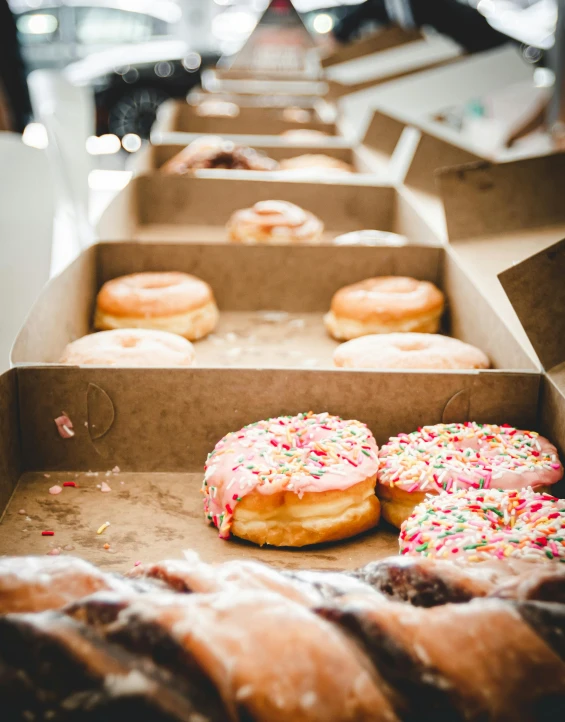 several boxes of different types of doughnuts on a table