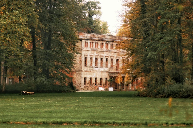 an old building is surrounded by trees and grass