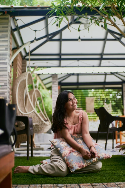 a woman is sitting on a rug inside the house