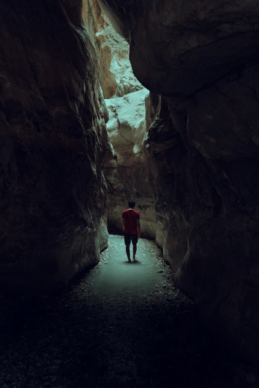 a person standing in a tunnel between two mountains