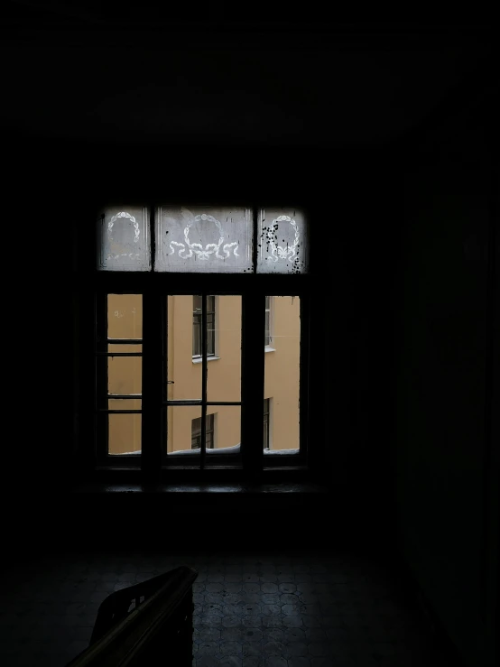 dark room with two windows and the door open