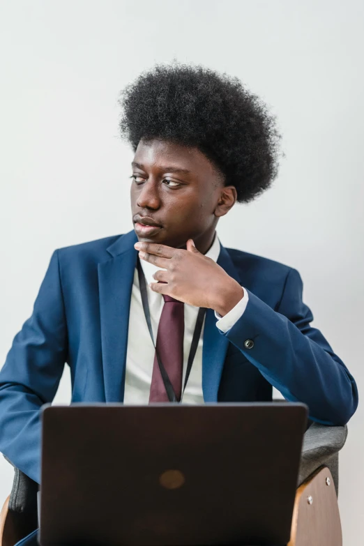 an african american business man sitting in front of a laptop