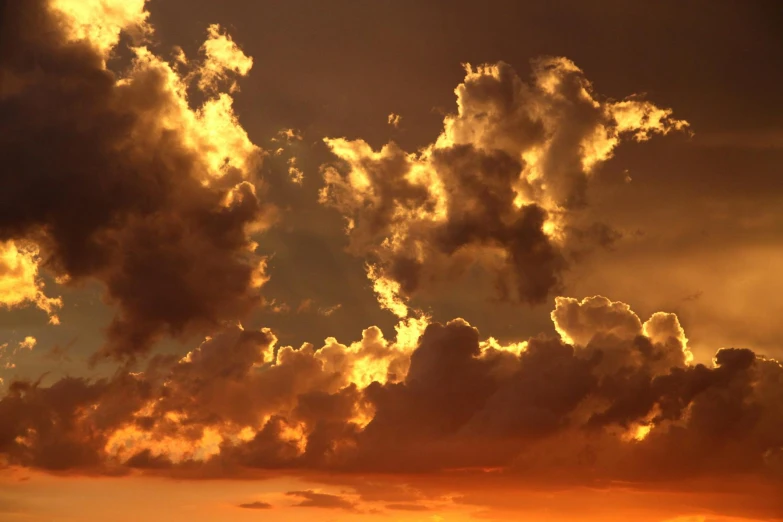 a jetliner flying through a cloudy sky at sunset