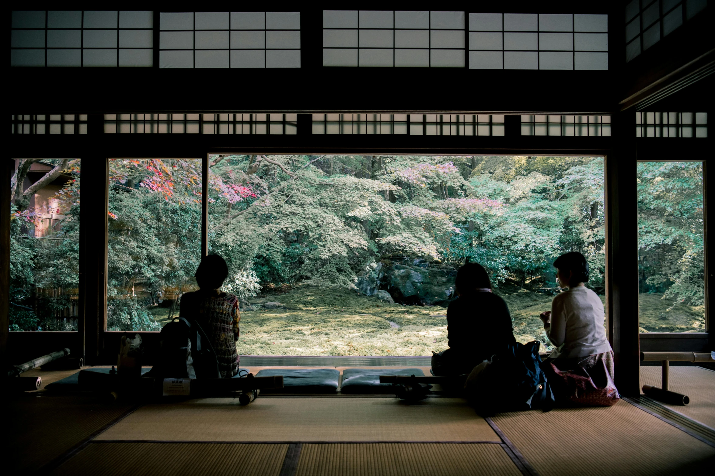 a couple sitting on top of a floor next to a window