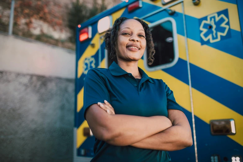 an african american woman standing in front of a blue and yellow fire truck